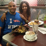 A young man and woman couple smiling sitting at a Plaza hotel restaurant in Las Vegas Nevada