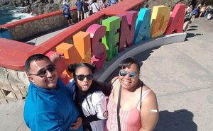photo selfie in front of colorful Ensenada Mexico sign.