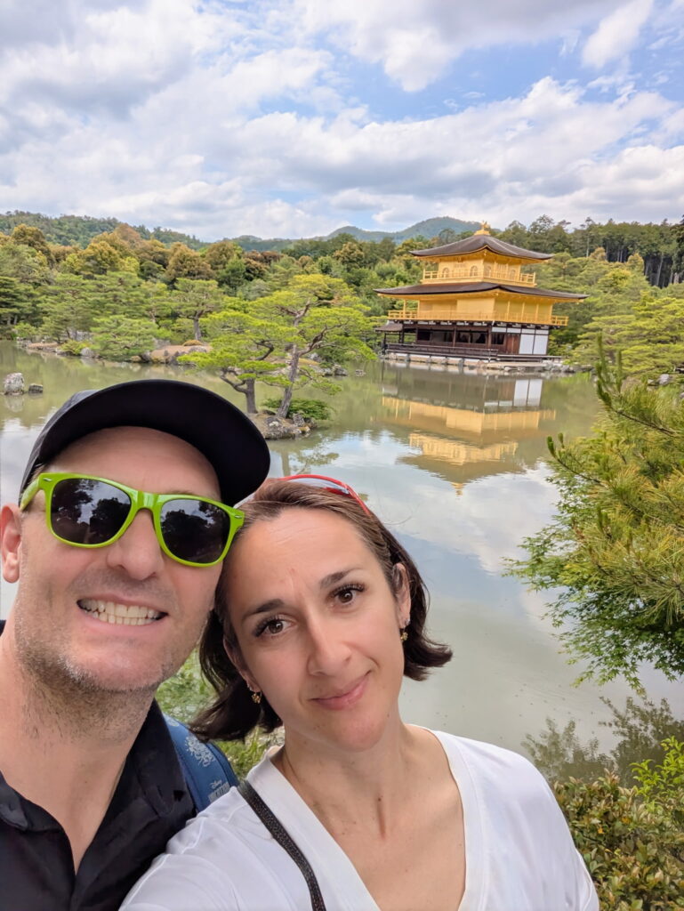 Andrew Smith and Bibian couple taking a selfie in front of the Kinkaku ji Golden Pavilion in Kyoto Japan