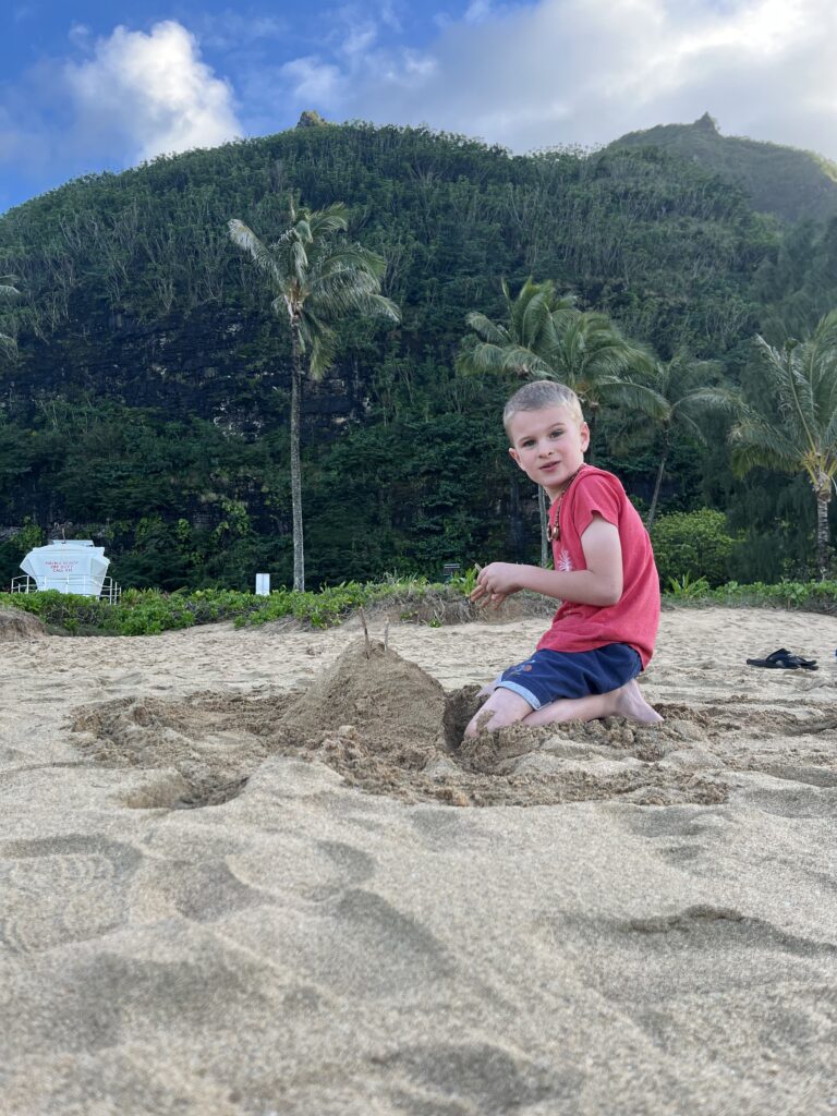 Lisa & Rob McKenzie with son Ian in Princeville on Kauai island Hawaii child playing in sand