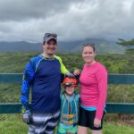Lisa & Rob McKenzie with son Ian in Princeville on Kauai island Hawaii small family father mother wife and son geared up for old sugar cane canals wearing headlamp for manmade tunnels