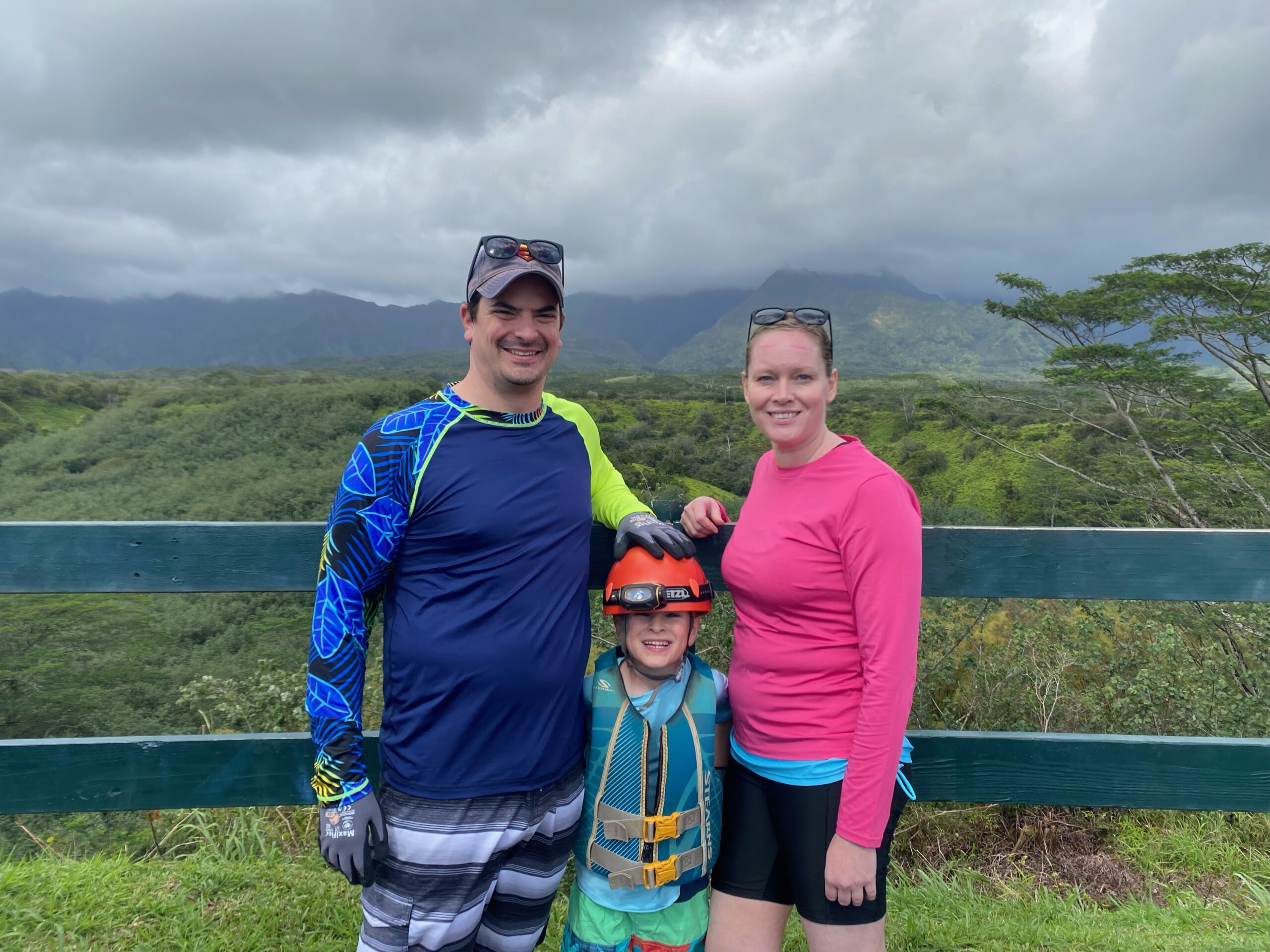 Lisa & Rob McKenzie with son Ian in Princeville on Kauai island Hawaii small family father mother wife and son geared up for old sugar cane canals wearing headlamp for manmade tunnels
